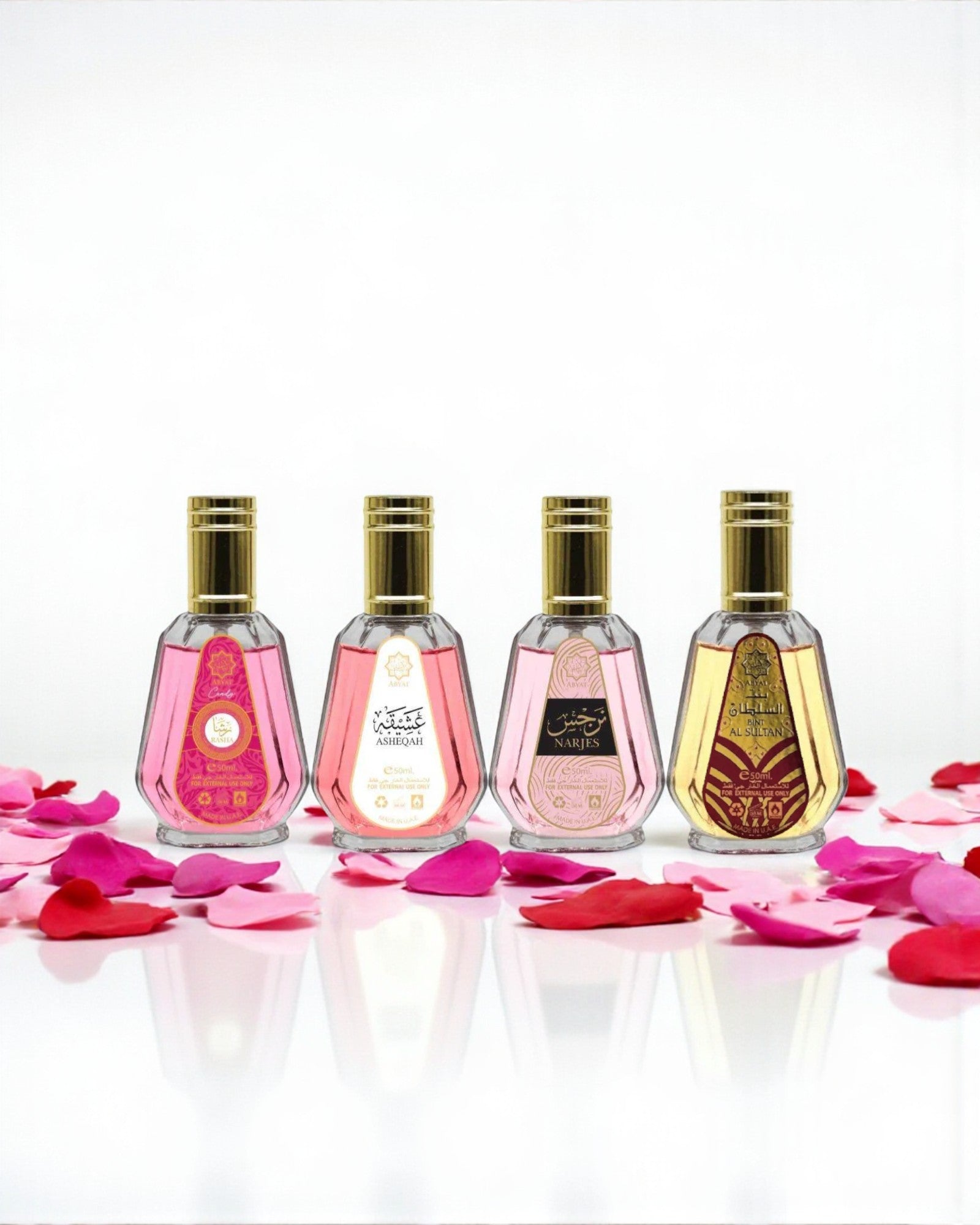 Pack Abyat – 4 eaux de parfum 50 ml (Bint Al Sultan, Asheqah, Rasha, Narjes) alignées devant fleurs, reflets sur surface brillante; palette florale-orientale avec touches vanillées et ambrées.