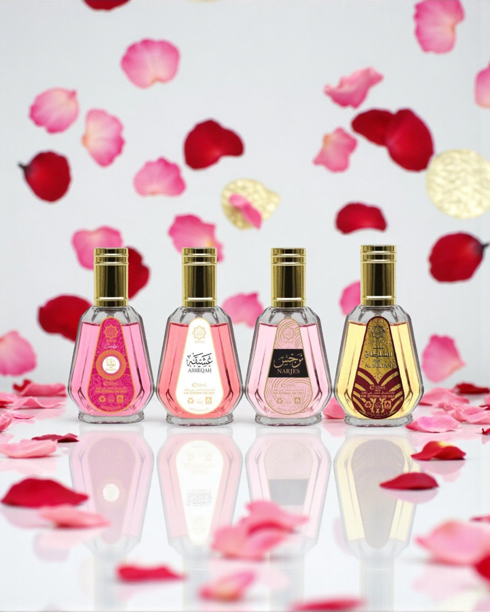 Coffret Abyat – 4 eaux de parfum 50 ml (Bint Al Sultan, Asheqah, Rasha, Narjes) alignées devant fleurs, reflets sur surface brillante; palette florale-orientale avec touches vanillées et ambrées.