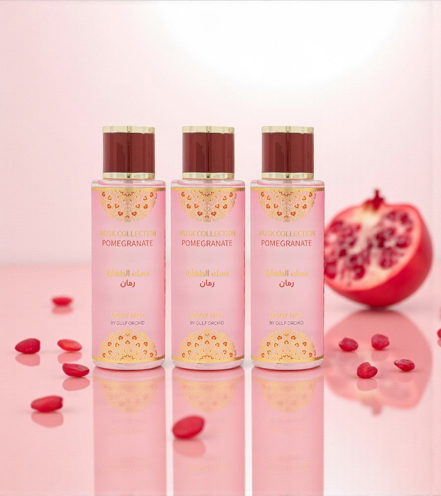 Pack 3 brumes Gulf Orchid Pomegranate 3 × 250 ml – flacons roses alignés, ambiance fruitée à la grenade, reflets sur surface rose brillante.
